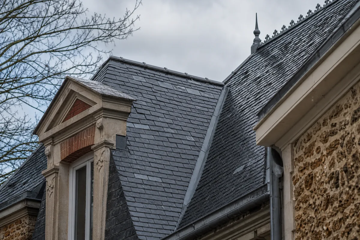 Toiture en ardoise d’une villa ancienne du Vésinet vue de près sous un ciel d’hiver
